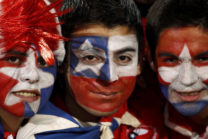 Tres aficionados chilenos posan ante la cámara con los colores de su bandera pintados en sus caras.sfeld stadium in Pretoria