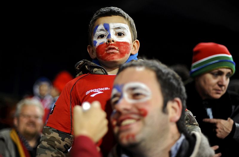 Un niño aficionado con la cara pintada con los colores de la bandera de Chile en la grada esperando el comienzo del paritdo entre Chile y España.