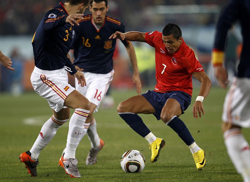 Chile's Sanchez fights for the ball with Spain's Pique and Busquets during a 2010 World Cup Group H match at Loftus Versfeld stadium in Pretoria