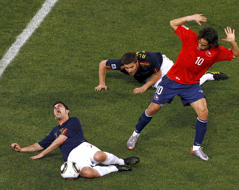 Spain's David Villa falls on the pitch as Chile's Jorge Valdivia reacts beside him during a 2010 World Cup Group H match at Loftus Versfeld stadium
