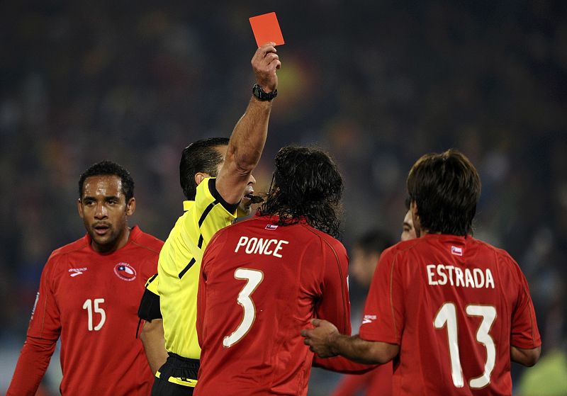 Referee Marco Rodriguez from Mexico shows the yellow card to Chile's Marco Estrada (13)  during a 2010 World Cup Group H match against Spain at Loftus Versfeld stadium in Pretoria