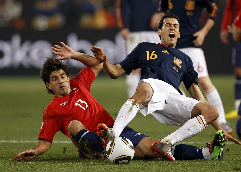 Chile's Estrada tackles Spain's Busquets during a 2010 World Cup Group H match at Loftus Versfeld stadium in Pretoria