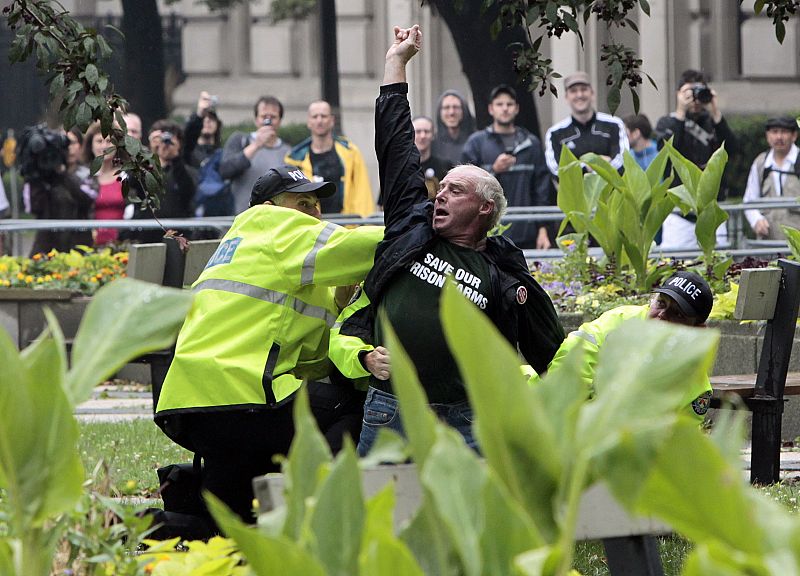 Un manifestante es reducido por agentes de policía en las calles de Toronto poco antes de que arranque el G-20