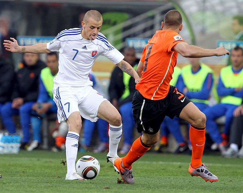 Vladimir Weiss intenta controlar el balón ante el la presión de holandés John Heitinga.