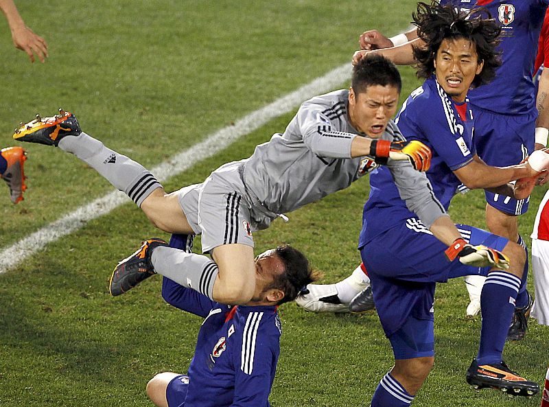 El portero japonés Tulio golpea a su compañero Eiji Kawashima durante una salida en el partido de octavos antes Paraguay.