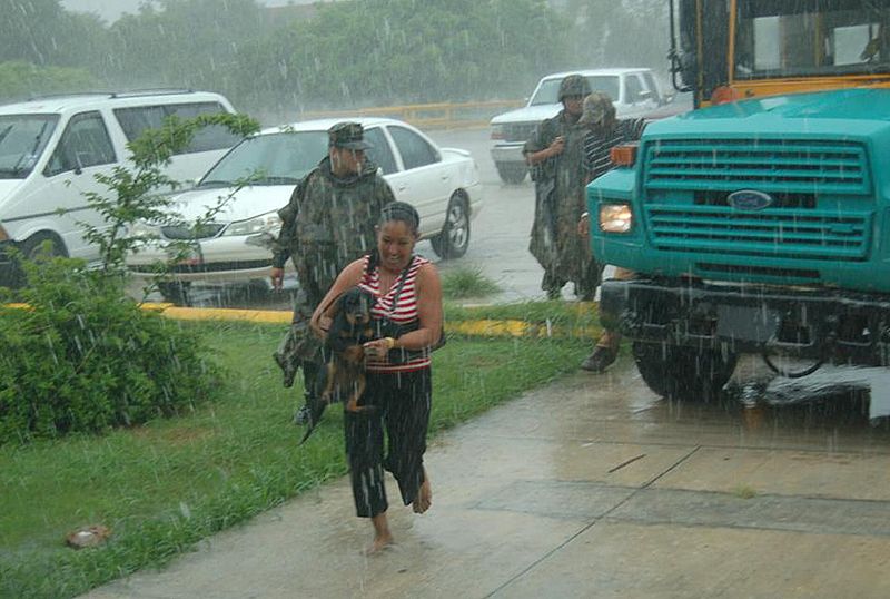 Una mujer corre para protegerse de la tormenta en una calle de Playa Bagdad (México)