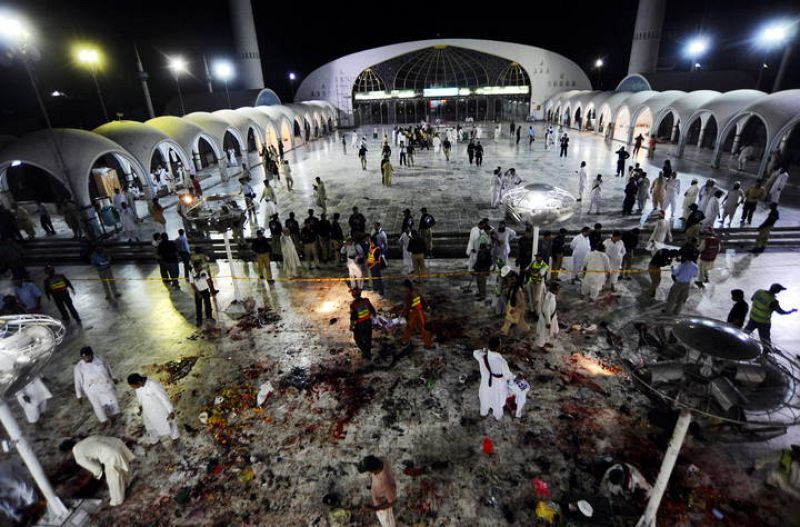 Oficiales de seguridad y de rescate se reúnen en el lugar en el que se llevó a cabo el triple atentado suicida  