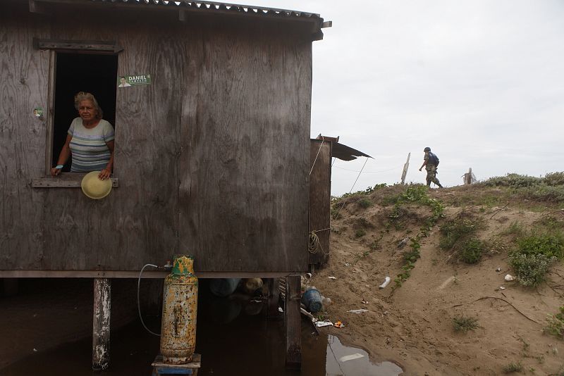 Una mujer mira desde su casa a un marín