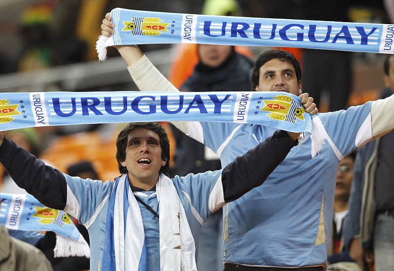 Soccer fans hold up scarves before the start of the 2010 World Cup quarter-final soccer match between Ghana and Uruguay at Soccer City stadium in Johannesburg