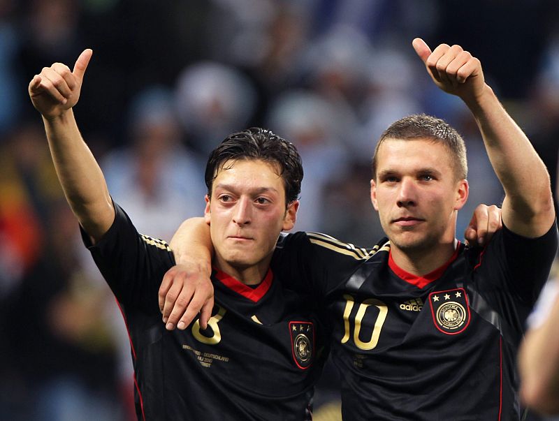 Los alemanes Özil (izquierda) y Lukas Podolski, saludan a los aficionados despues de que Alemania derrotara a Argentina por 4-0