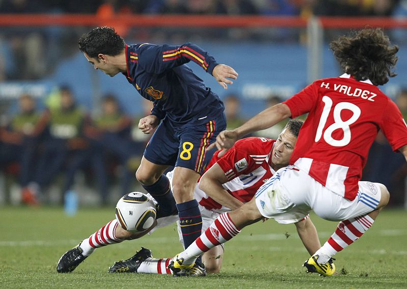 Xavi lucha por el balón con el paraguayo Santana