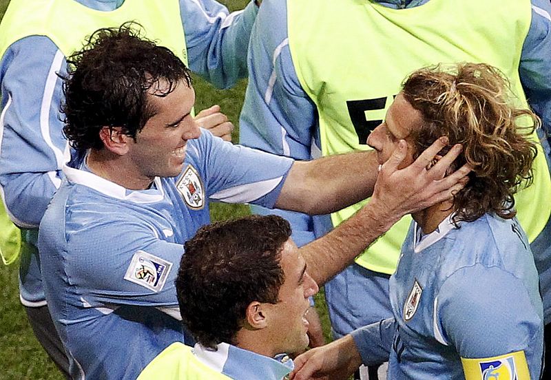 Uruguay's Forlan celebrates with teammates after scoring against Netherlands during their World Cup semi-final soccer match at Green Point stadium in Cape Town