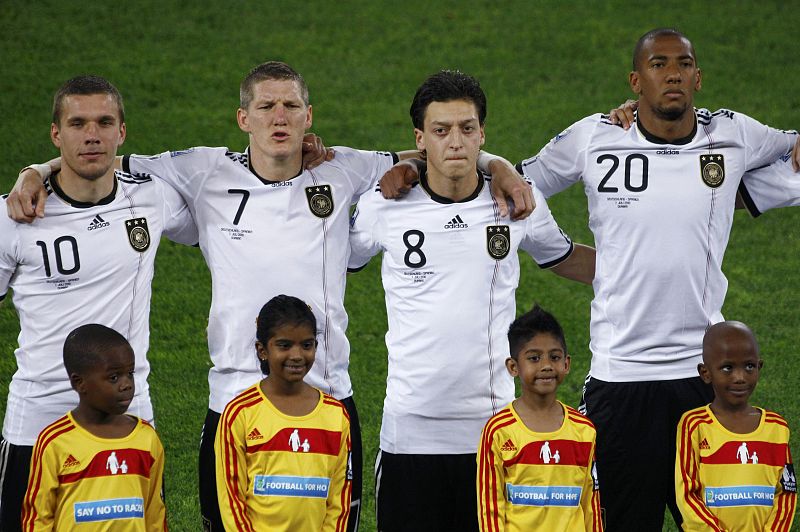 Germany's players stand with mascots during the singing of anthems at a 2010 World Cup semi-final soccer match against Spain in Durban