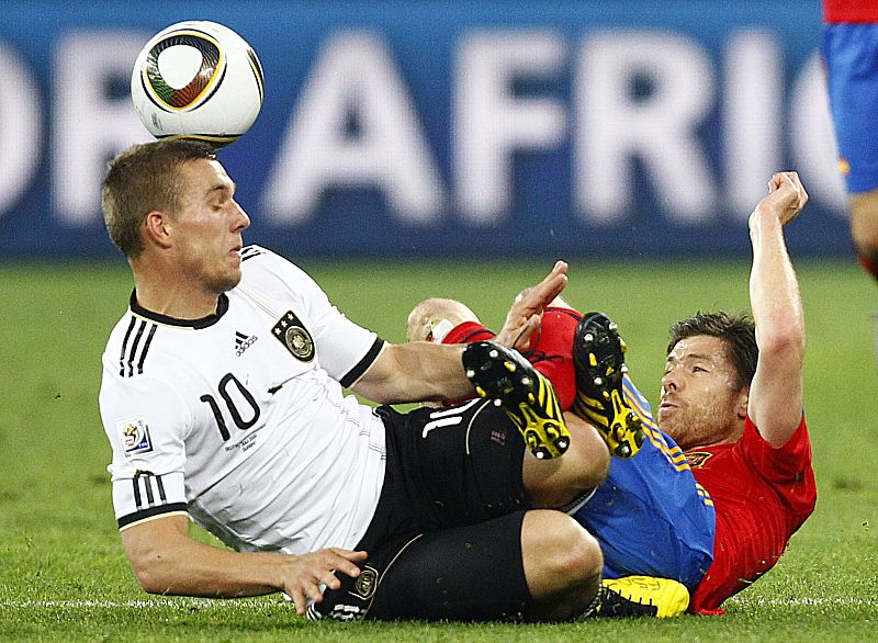 Germany's Lukas Podolski fights for the ball with Spain's Xabi Alonso during their 2010 World Cup semi-final soccer match at Moses Mabhida stadium