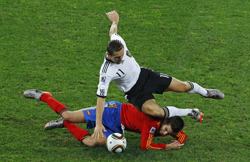 Germany's Miroslav Klose fights for the ball with Spain's Gerard Pique during their 2010 World Cup semi-final soccer match at Moses Mabhida stadium in Durban