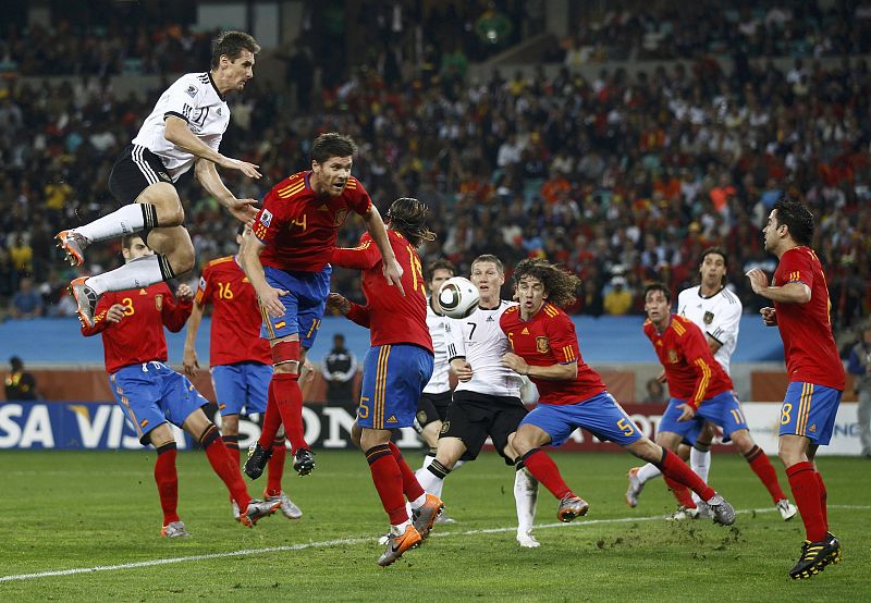 Germany's Klose and Spain's Alonso jump for the ball during the 2010 World Cup semi-final soccer match in Durban