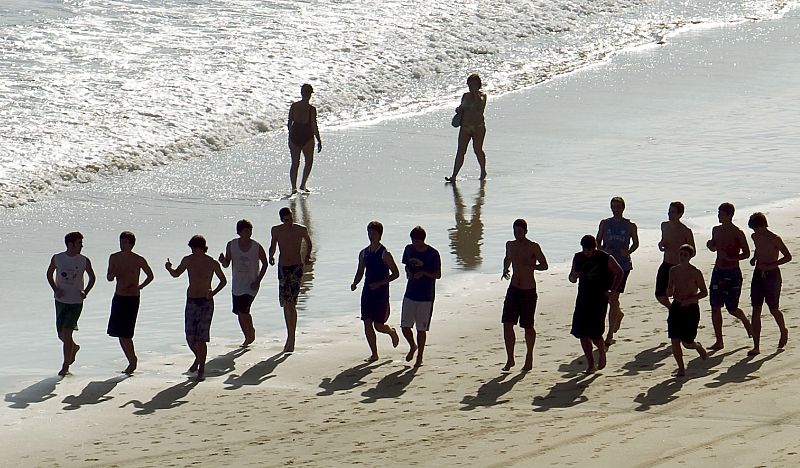 Un grupo de jóvenes se refrescan en la playa de la Concha en San Sebastián.