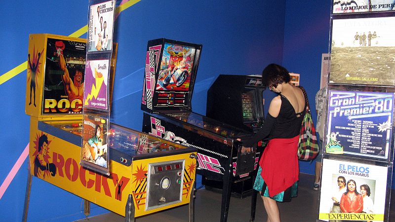 'Pin-balls' y máquinas de 'marcianitos' en el salón recreativo de la exposición "Quinquis de los 80".