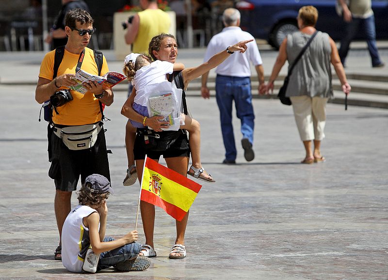 Una pareja y sus dos hijos pasean por el centro de Valencia a pesar de las altas temperaturas.