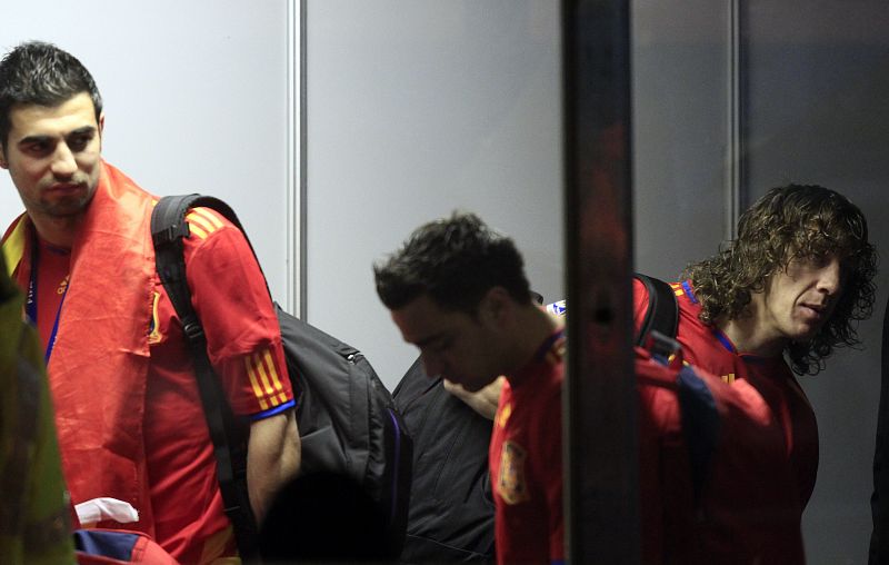 Spain's players wait in line at the airport check-in as the team leaves after winning the 2010 World Cup in Johannesburg