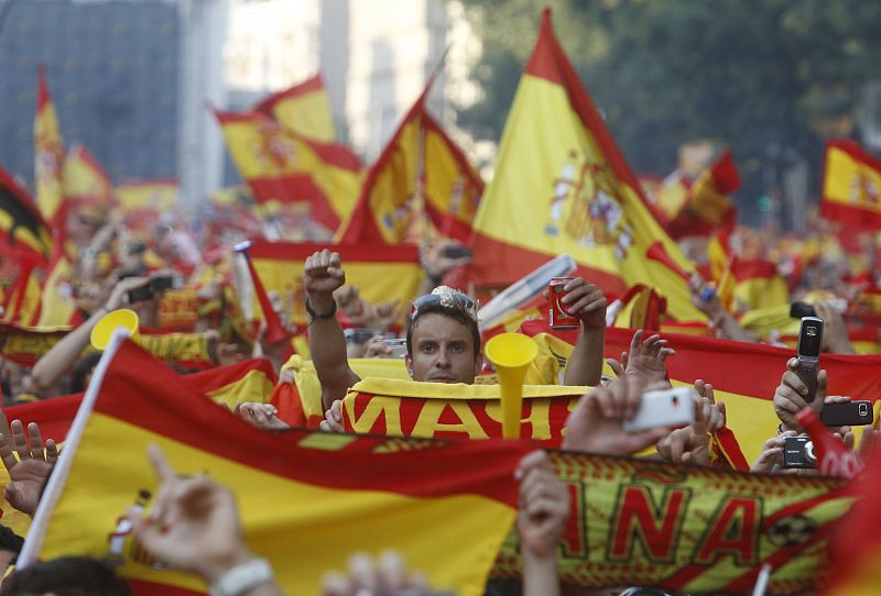 Soccer fans hold Spain's national flags as they gather to watch a public screening of the World Cup 2010 final soccer match in downtown Madrid