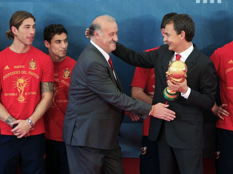El presidente del Gobierno, José Luis Rodriguez Zapatero, bromea con Vicente del Bosque mientras sujeta el trofeo de la Copa del Mundo.