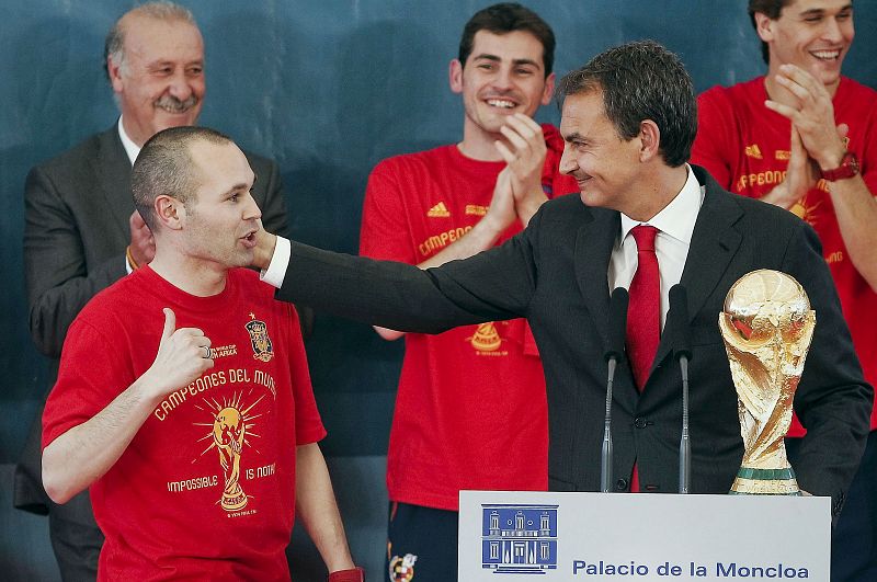 El presidente del Gobierno sostiene el trofeo junto al jugador Andrés Iniesta, autor del gol que dio la victoria a España.