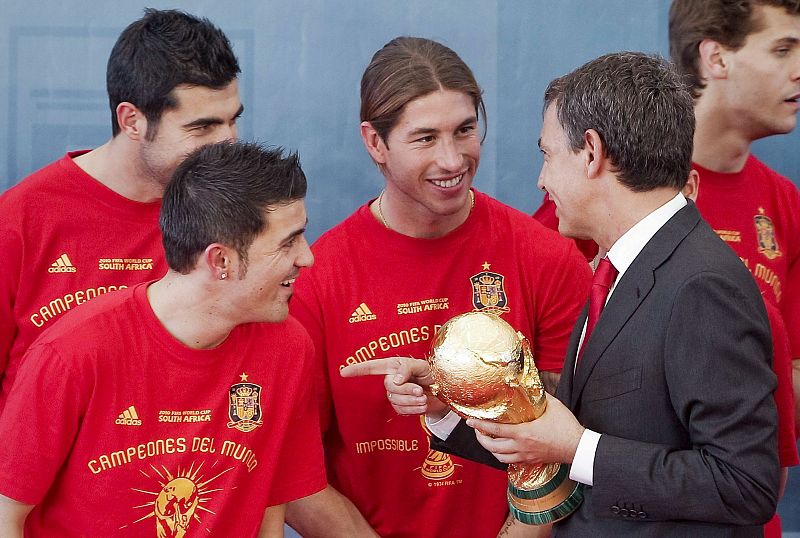 El presidente del Gobierno de España, José Luis Rodríguez Zapatero, coge el trofeo de la Copa del Mundo mientras dialoga con los defensas Raúl Albiol, Sergio Ramos y el delantero David Villa. durante la recepción ofrecida al combinado nacional.