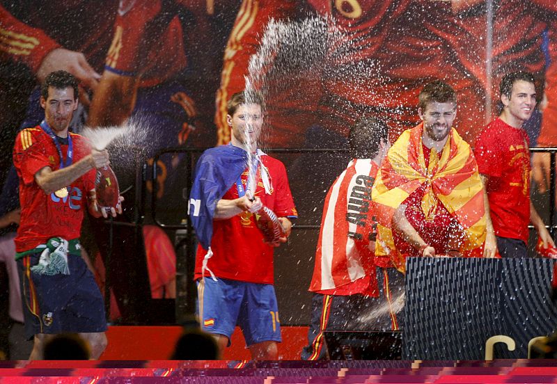 Los jugadores de la selección española de fútbol, Sergio Busquets, Xabi Alonso y Gerard Piqué (i-d), animan con cerveza la fiesta.