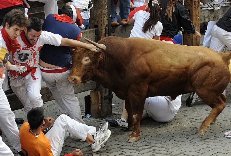 A woman runner is gored by a fighting bull during the ninth running of the bulls of the San Fermin festival in Pamplona