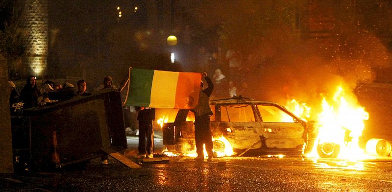 Escondidos detrás de una barricada nos muestran la bandera irlandesa