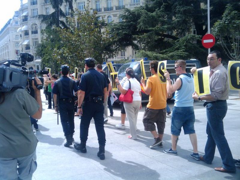 Una veintena de personas, que dicen llamarse Plataforma Pinocho, piden la dimisión de Zapatero a las puertas del Congreso de los Diputados.