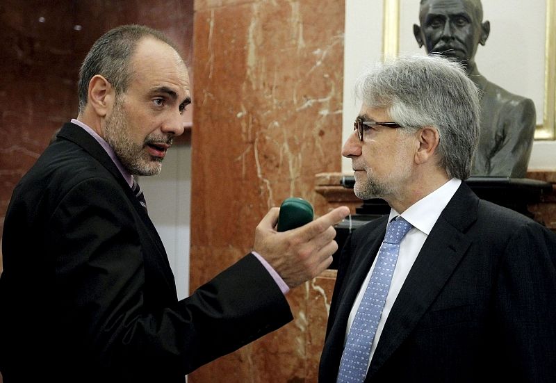 El portavoz de ERC, Joan Ridao, conversa con el portavoz adjunto de CiU en el Congreso, Josep Sánchez Llibre, en los pasillos de la cámara baja durante uno de los descansos de la sesión de esta mañana.