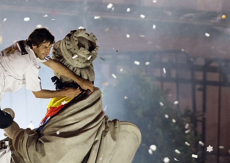 Raúl coloca una bandera sobre la fuente de Cibeles en el centro de Madrid