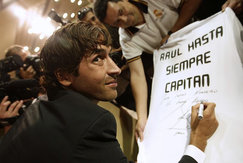 Real Madrid player Raul Gonzalez signs a shirt that reads "farewell captain" after his news conference in Madrid