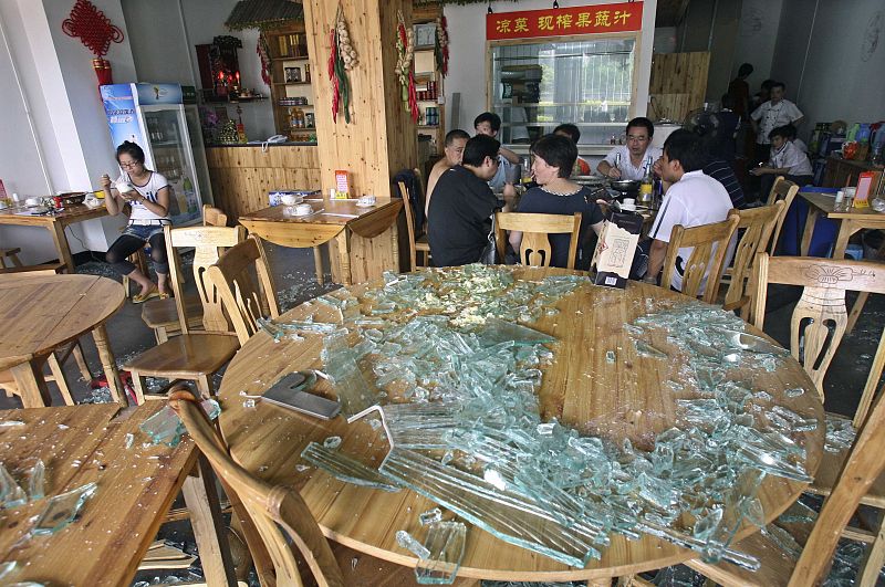 Los clientes de un restaurante cercano al lugar de la explosión rodeados de escombros.