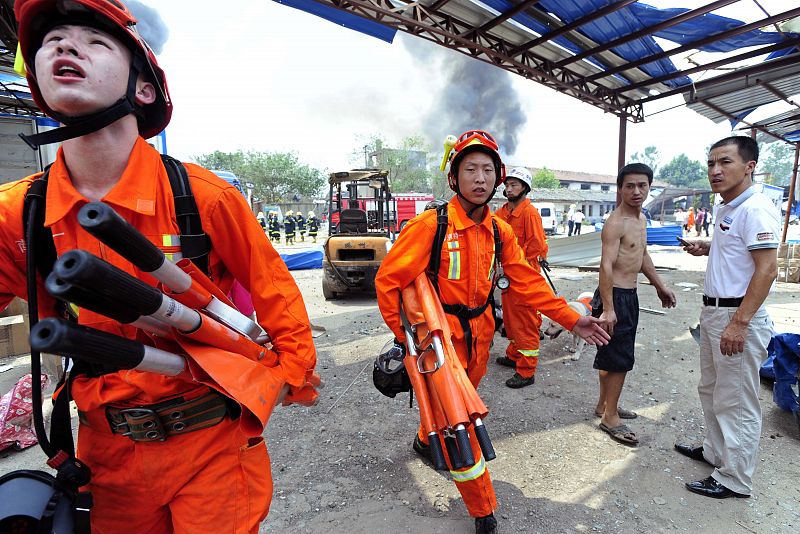 Los bomberos se apresuran a la fábrica donde se ha producido la explosión para sofocar el fuego.