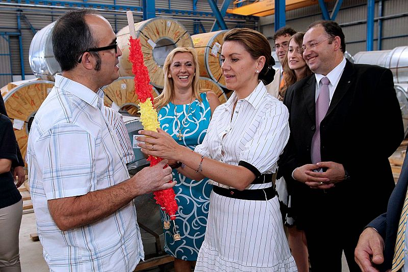 Maria Dolores de Cospedal recibe un regalo de unas banderillas que le hizo un empleado de la compañía Grupo Álvarez, durante su visita este miércoles a la empresa siderúrgica.