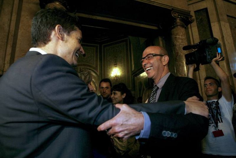 El conseller de Medio Ambiente y Vivienda de la Generalitat, Francesc Baltasars, recibe la felicitación del portavoz de la plataforma Prou!, Leonardo Anselmi. 
