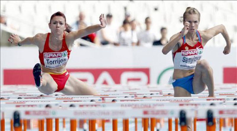 La atleta española Ana Torrijos (izda) y la rusa Olga Samylova (dcha) durante su participación en la tercera serie de la prueba de 100 m vallas en el Campeonato de Europa de Atletismo  Barcelona 2010.