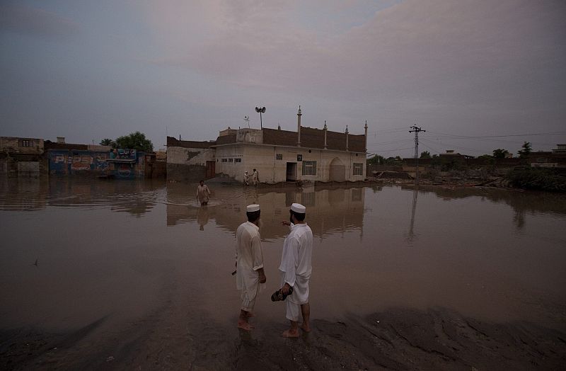 Men stood outside their mosque as flood waters receded in Nowshera Pakistan