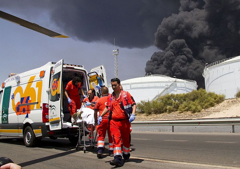 Miembros del 061 evacúan a uno de los tres operarios que han resultado heridos de diversa consideración en el incendio
