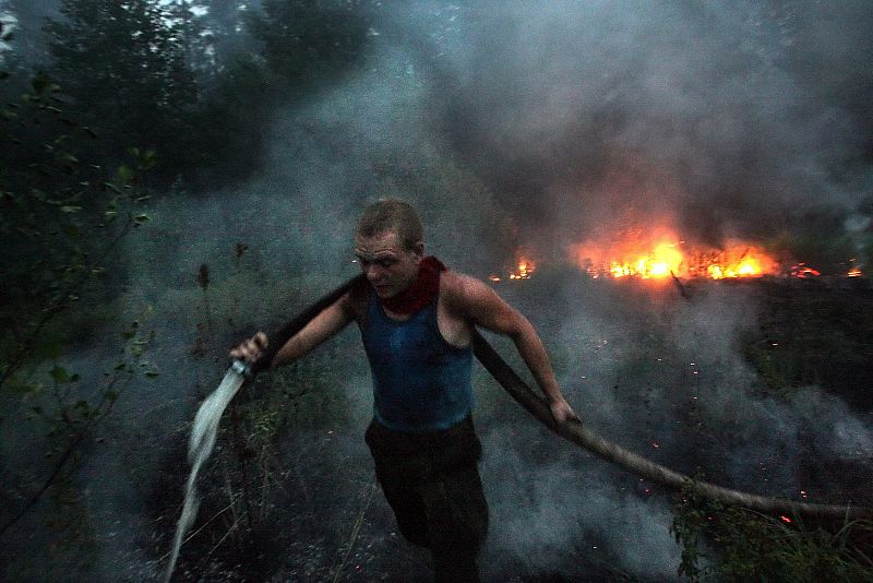 Un hombre trabaja en las labores de extinción de un incendio forestal en la villa de Ryazanovskiy