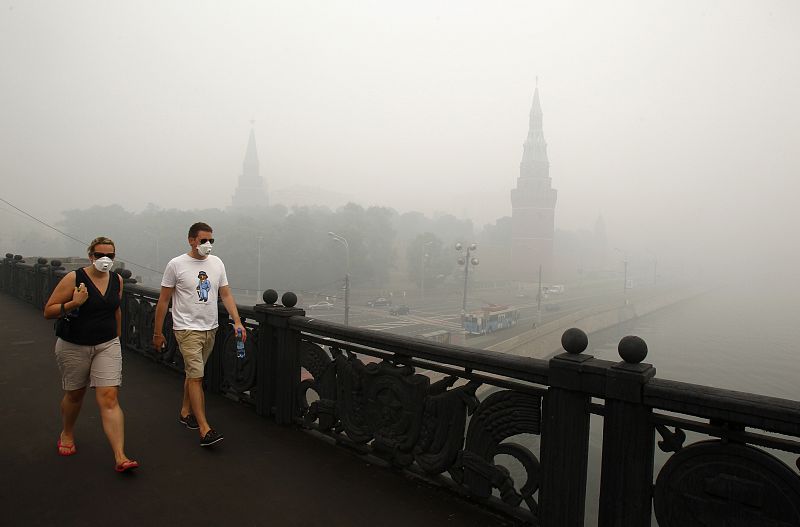 People wear masks to protect themselves from the smell of heavy smog, caused by peat fires in nearby forests, in central Moscow