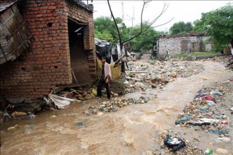 Un hombre observa una calle inundada junto a su casa en la ciudad india de Jammu en Cachemira