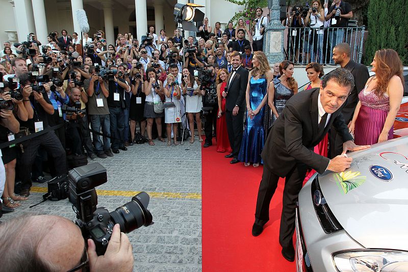 El actor Antonio banderas firma en el capó de un coche a su llegada a la gala "Starlite"