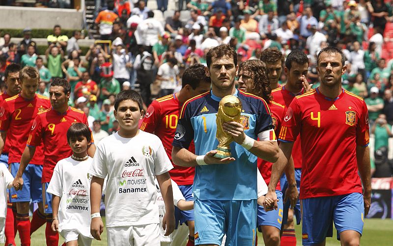 Iker Casillas lleva la Copa FIFA en sus manos mientras entra a la cancha con sus demás compañeros para enfrentar a México.