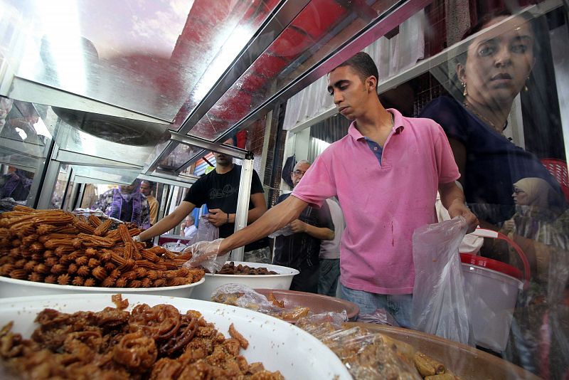 A vendor sells cakes and chebbakia, a traditional fried honey and flour pastry, to customers ahead of Ramadan