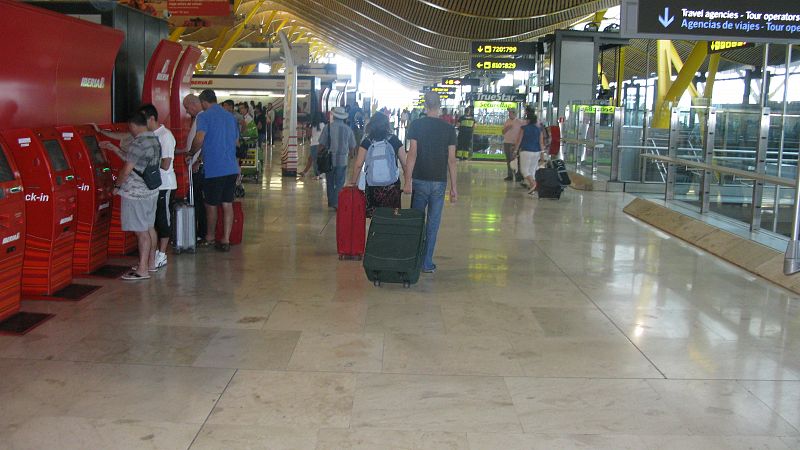 Dos pasajeros se dirigen hacia el mostrador de facturación en Barajas