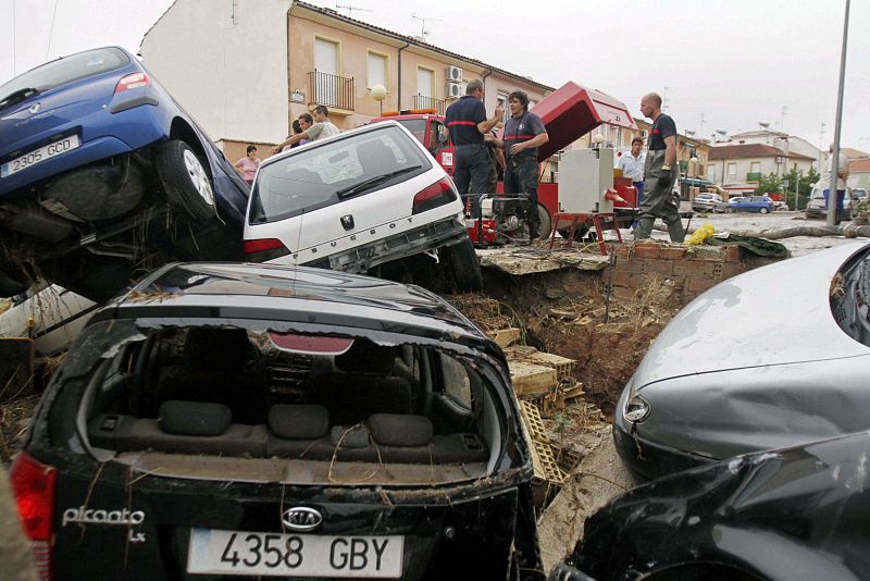 Varios coches destrozados en una calle inundada de la localidad de Aguilar de la Frontera. Las fuertes lluvias caídas durante la noche han provocado la muerte de tres personas en Córdoba.